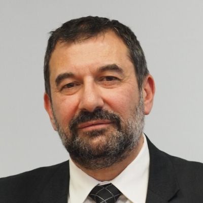 In the picture, Kamen Dobrev is wearing a black suit, white shirt, and black tie.